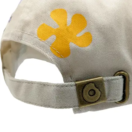 Photo of a fabric strap with an antique brass buckle, with a custom embossed logo on the surface of the buckle