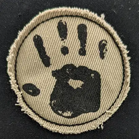 Photo of a fabric patch with a hand print logo screen printed onto it