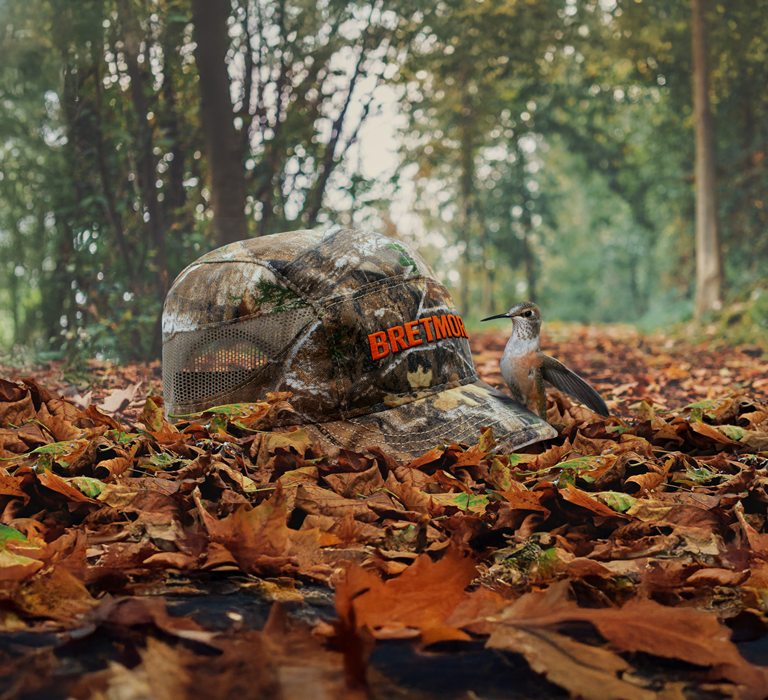 Background image of a cap with a leather patch on a post with hummingbirds hovering around it